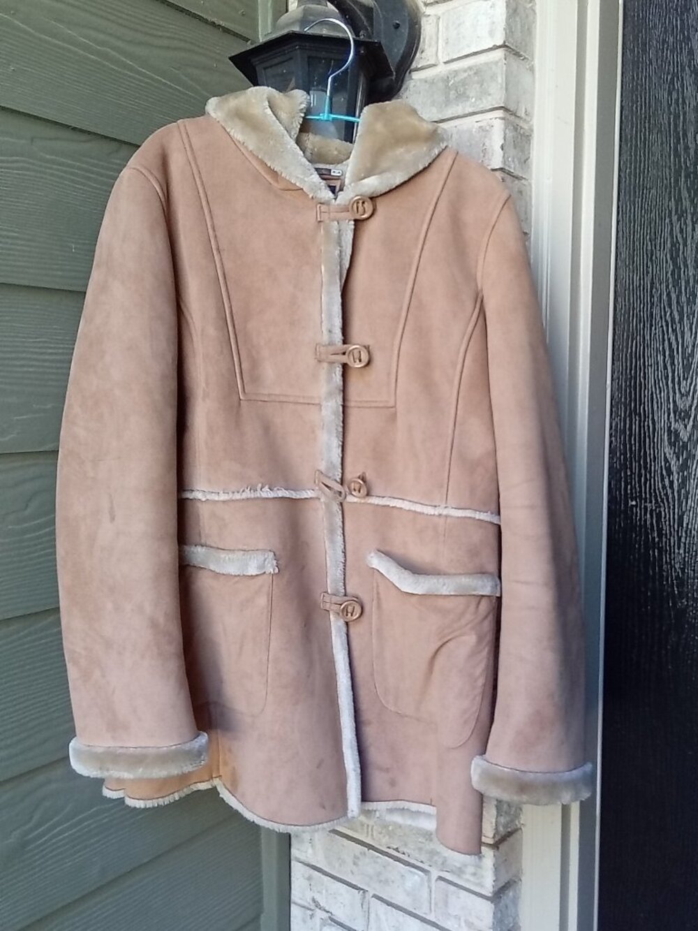 The Jones New York Shearling Jacket is a stylish mid-length coat